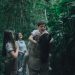 A joyful family bonding in a lush green forest, embracing nature.